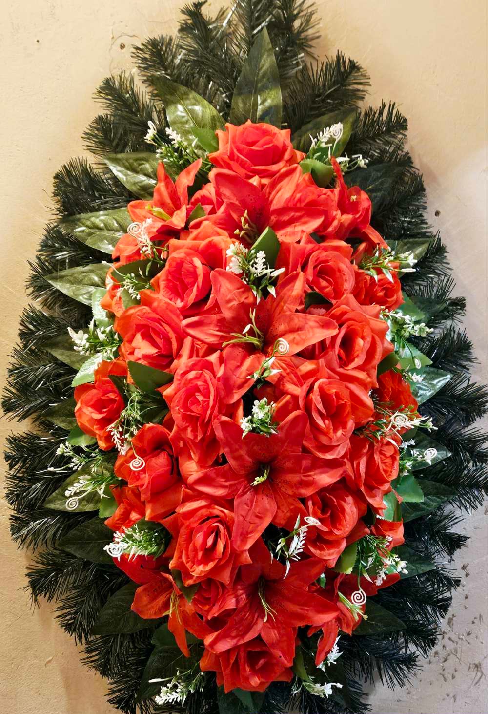 Траурен венец с червени рози и червени лилии, с зеленина и декоративни бели елементи