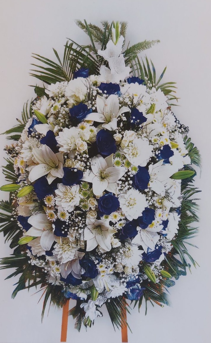 Траурен венец с бели лилии и рози, зеленина и акцентни бели цветя, поставен на стойка