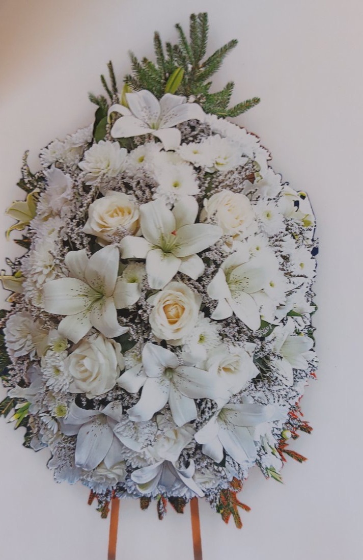 Траурен венец с бели и зелени цветя, кремави рози, поставен на стойка